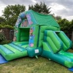 A jungled bounce themed bouncy castle with slide side view