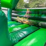 Inside view of t-rex themed bouncy castle with slide